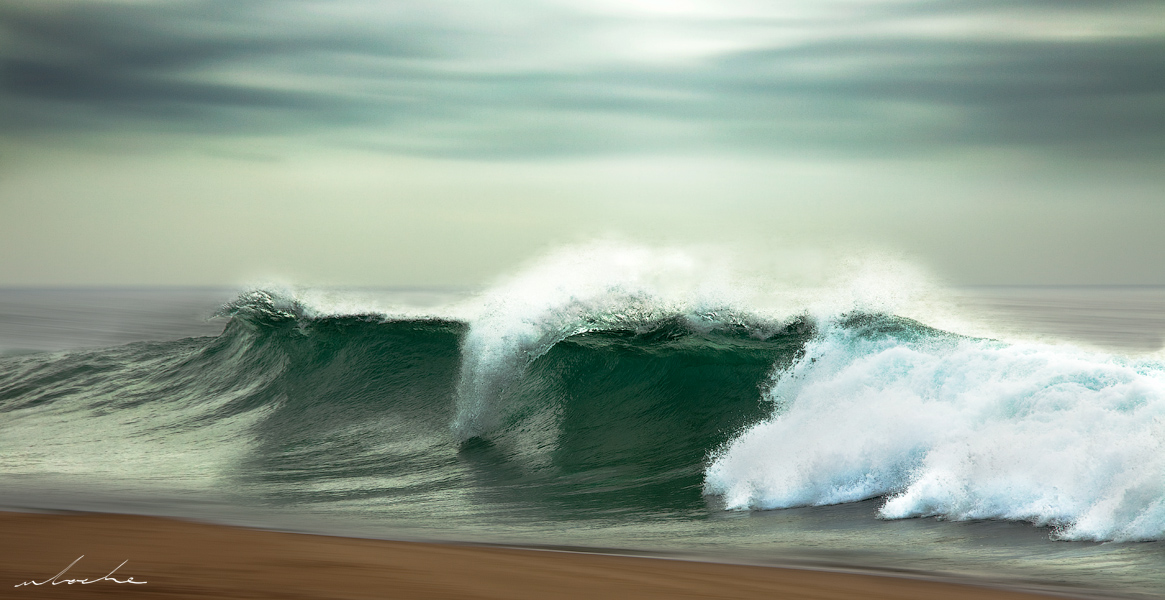 A colour photograph of a wave begins to break onto the beach